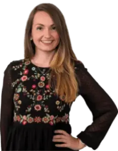 Freigestelltes Porträt einer lächelnden Frau mit langen braunen Haaren und einer schwarzen Bluse mit farbiger Blumenstickerei, die für den Kundenservice steht.